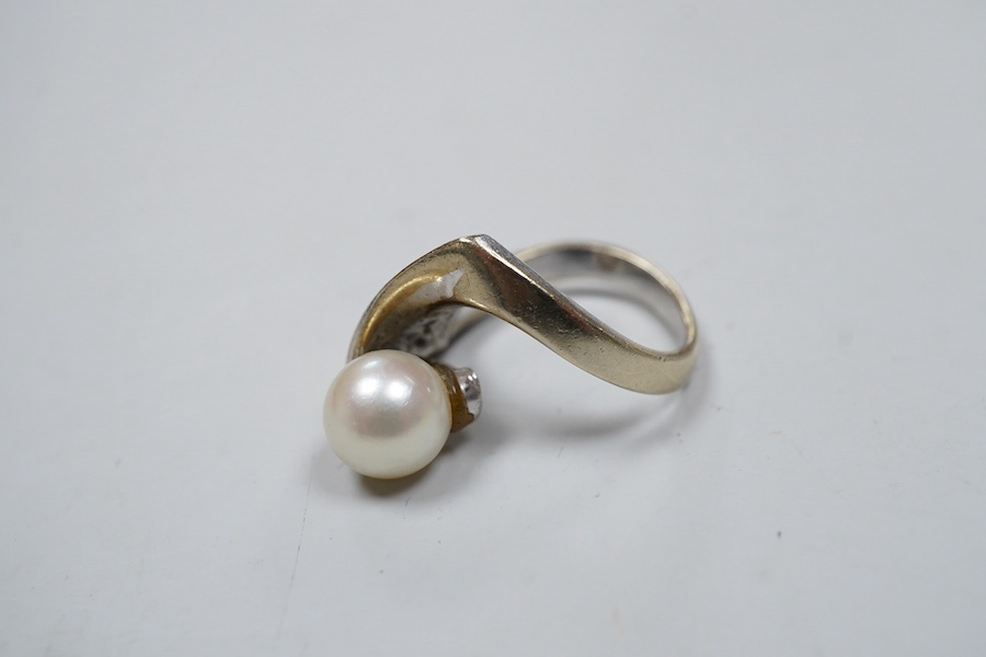 A cultured pearl ring, set with a cultured pearl, to an asymmetrical curved mount in white gold, size J1/2, stamped K14WG, maker's mark, gross weight 6 grams, Condition: Overall good - wear to rhodium, glue residue to ba